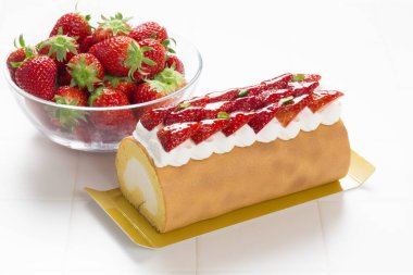 Üstünde çilek ve krema olan kek.