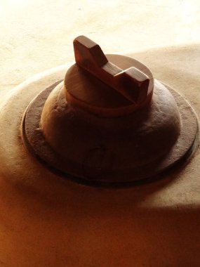 Metal kapak sıcak ışıkta pürüzsüz yüzeyde duruyor