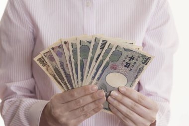 Japon kadın beyaz arka planda yen banknotları tutuyor