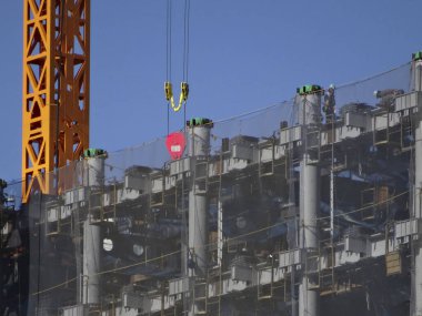 Endüstriyel vinç ve inşaatın düşük açılı görüntüsü mavi gökyüzüne karşı         