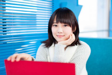 Bilgisayarlı güzel Asyalı kadının yakın plan portresi.