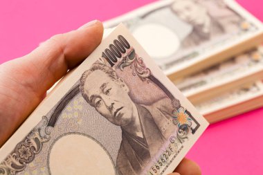 Japon parası, yeni banknotlar tutan bir adam.
