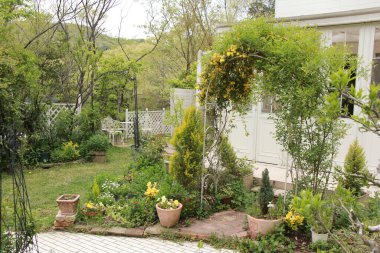 Beyaz sarayın önündeki bahçede yeşil bitkilerden ve sarı çiçeklerden oluşan güzel bir kemer.