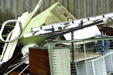 Dışarıdaki ahşap çitlere karşı atılmış ev eşyaları.