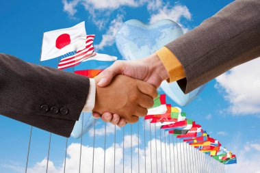 İş ortaklarının bayraklar üzerinde el sıkışırken yakın plan görüntüsü              