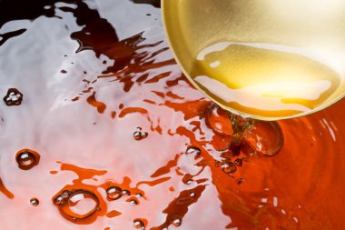 Koyu parlak yüzeye dökülen altın sıvı