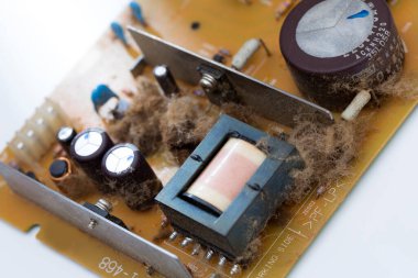 Elektronik devre kartının toz ve tozla yakın çekim görüntüsü.