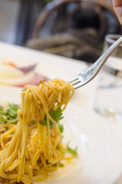 Çatal dolusu spagetti ve taze maydanoz.