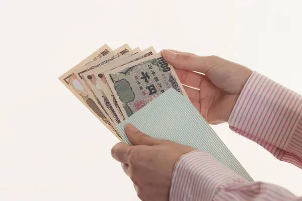 日本のお金を持っている女性の手 白い背景に孤立した円紙幣 — ストック写真