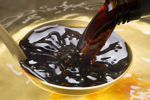 pouring brown liquid, close up