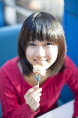 Güzel Japon kadın restoranda yemek yiyor.