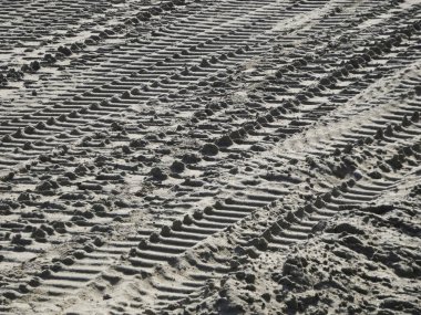 Üst üste binen lastik izleri kumlu dış yüzeyi kaplıyor.