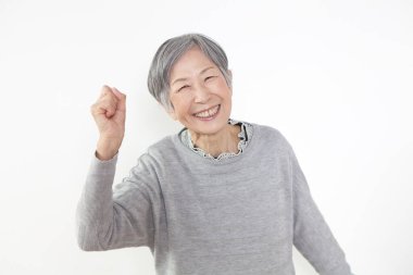 Stüdyoda gri kıyafetler giyen mutlu bir son sınıf öğrencisi. 