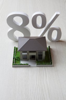 ev modeli ve% 8 tabela ahşap arka planda  