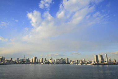 Bulutlu gökyüzü altında modern şehir mimarisi, uzak görüş