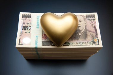 Altın kalpli Japon Yen banknotları beyaz arka planda.