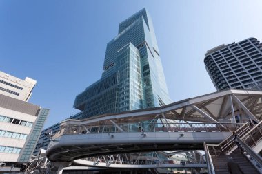 Modern gökdelen, yaya köprüsünün ve binaların üzerinde yükseliyor.