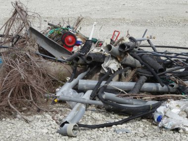 Dökülen metal borular birbirine dolanmış kablolar ve dışarıda duran kuru dallar.