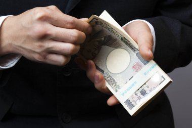 Japon Yen 'inin elleri. Arka planda para, yakın plan.