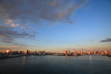 Bulutlu gökyüzü altında modern şehir mimarisi, uzak görüş