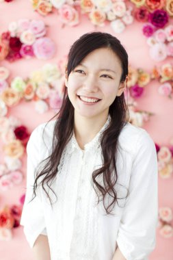 Güzel Asyalı kadın pembe arka plana karşı çiçekli 