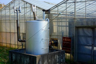 Seranın dışındaki metal tankta cam paneller var.