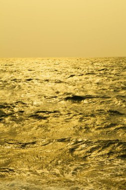 Denizin üzerinde güzel bir gün batımı, akşam güneşinde deniz dalgaları. 