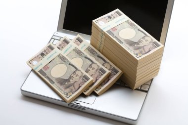  Arka planda Japon Yen para ve dizüstü bilgisayar yığını
