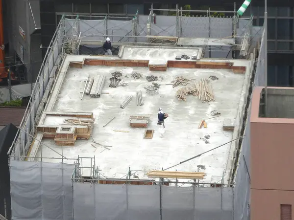 İşçiler malzeme ve araçlarla çatı inşa ediyorlar