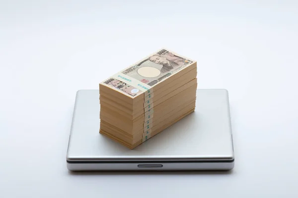背景に日本円マネーとノートパソコンのスタック — ストック写真