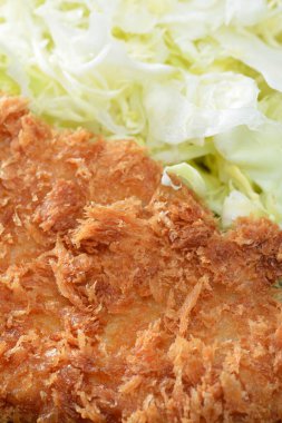 Parçalanmış lahana yanında kızarmış pirzola.