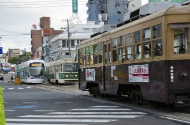 Modern şehir Japonya 'da gündüz tramvayı sokak sokak geziyor.