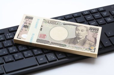 Klavye arka planında Japon yen banknotları. 
