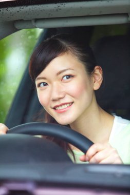 Arka planda Japon kadın araba kullanıyor.
