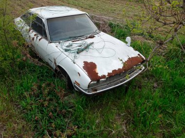 Yeşil ormanda hasarlı eski bir araba