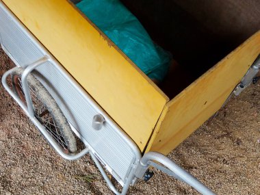 Çakıl taşı yüzeyinin yanında duran sarı metal araba.