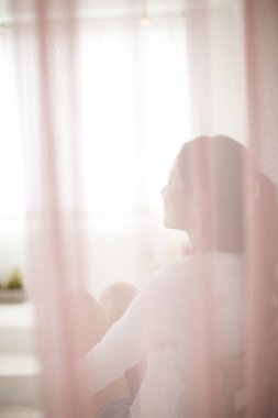 Odadaki kanepede oturan genç kadın.