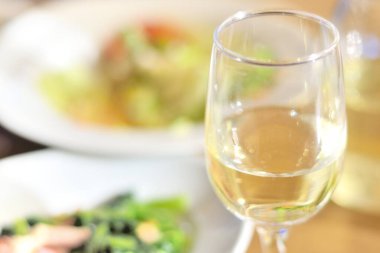 Taze salatanın yanında bir kadeh beyaz şarap.