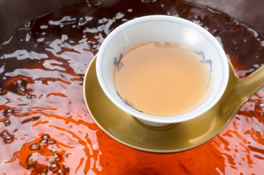 Bir fincan sıcak çay tutan bir kadın.