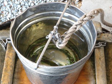 Su ve iple doldurulmuş metal kova.