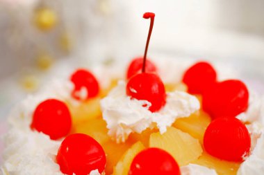 Üstünde kirazlar olan çilekli sütlü kek.