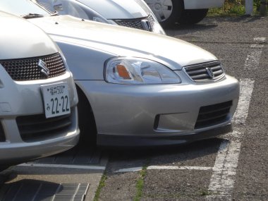 Güneşli alana yakın park edilmiş gümüş arabalar.