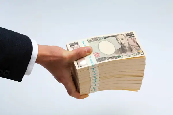 バックグラウンドにおける日本円のお金の手 — ストック写真