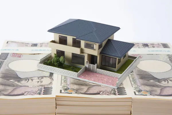 日本円紙幣と小さな家モデル — ストック写真