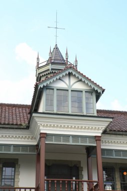 Sivri çatılı ve pencereli süslü bina kulesi