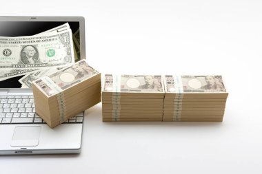Beyaz arkaplanda banknotları olan dizüstü bilgisayar