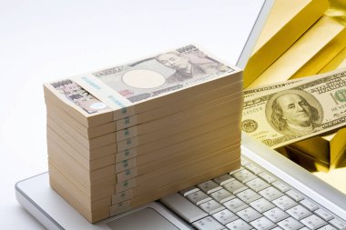 Beyaz arka planda dizüstü bilgisayarı olan Yen banknotları