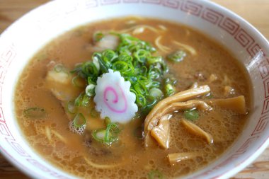 Arka planda Japon yemeği olan bir kase erişte, yakın plan.