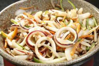 Dilimlenmiş sebzeli taze kalamar salatası.