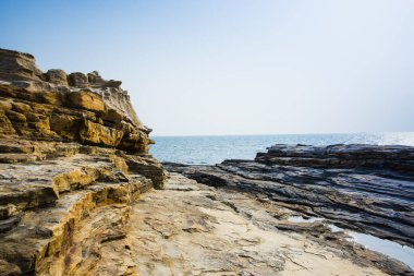 Sahildeki kayalık deniz manzarası, deniz dalgaları ve kayalar.   